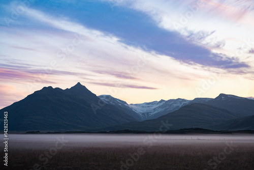 Obraz na płótnie Twilight over Vatnajökull glacier in Iceland, with snow-covered peaks, pastel sky, rising crescent moon, and mist-covered plains evoking stillness and grandeur. w salonie