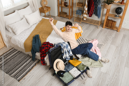 Happy male tourist packing ...