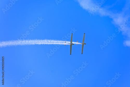two planes synchronously flying during an aerial performance on the beatiful semi clear blue summer sky
