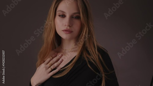 Wallpaper Mural Beautiful girl with gold jewelry and loose hair in black clothes posing on a dark background. Beauty face and hair. Video 4k Torontodigital.ca