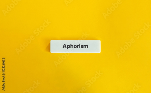Aphorism, short, pithy expression. Text on Block Letter Tile on Yellow Background. Minimal Aesthetic.