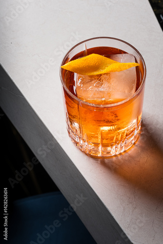 Old Fashioned Cocktail Amber Liquid Ice Cube and Orange Twist