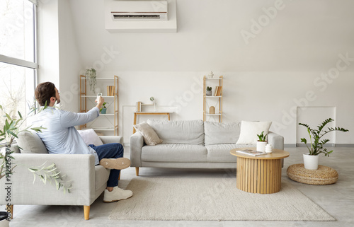 Young man turning air condi...
