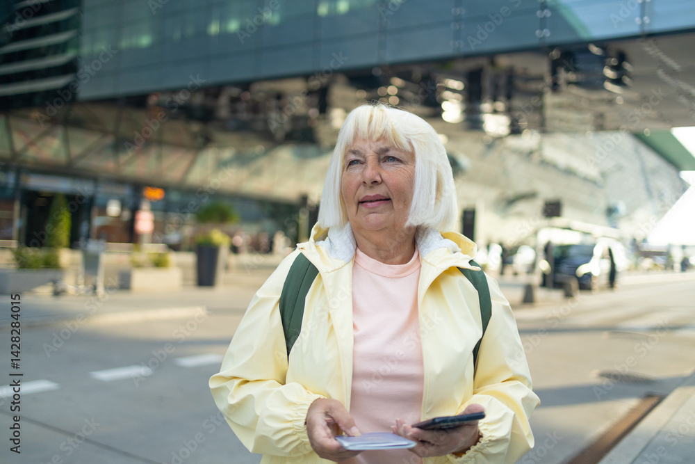 Senior female tourist in airport hold backpack passport ticket schedule to check flight departure gate. Travel and tourism concept, people with backpack on shoulders. High quality photo