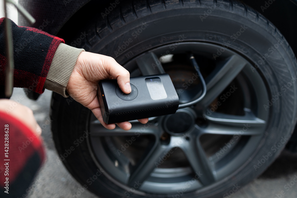 man driver hand inflating tires of vehicle, removing tire valve nitrogen cap for checking air pressure and filling air on car wheel at gas station. self service, maintenance and safety. High quality