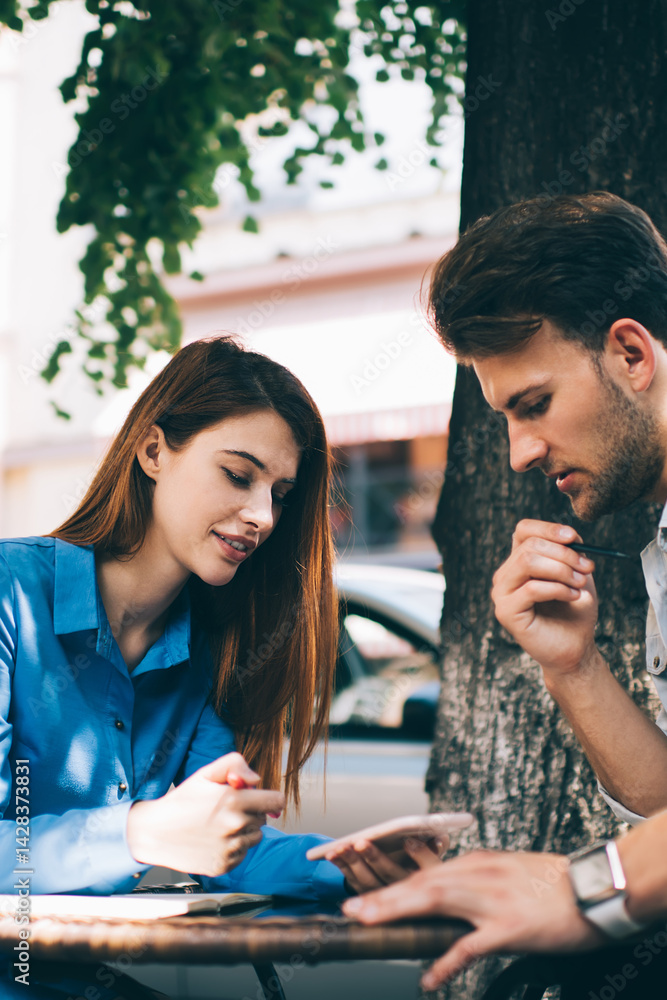 Young woman and man having discussion in street cafe