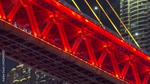 Chongqing, China - April 11, 2025: Train passing in Qiansimen Bridge at night  and views of Hongyadong Cave from Riverside park