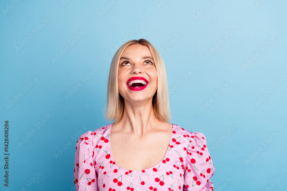 Photo of glad gorgeous lovely girl wear trendy pink print clothes look empty space isolated on blue color background Photo of glad gorgeous lovely girl wear trendy pink print clothes look empty space isolated on blue color background