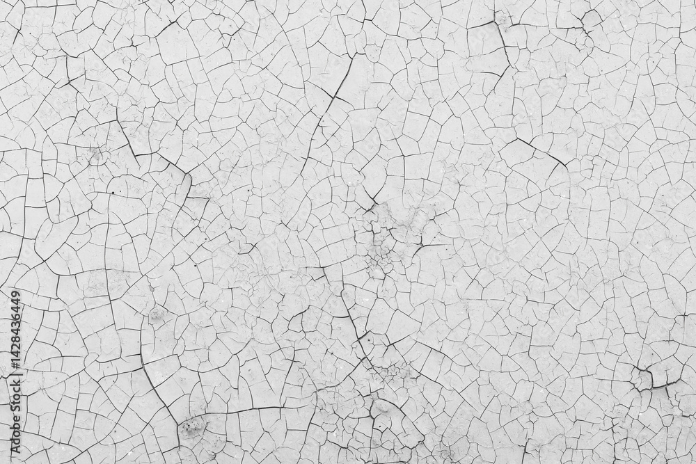 White peeling paint on the wall. Old concrete wall with cracked flaking paint. Weathered rough painted surface with patterns of cracks and peeling. High resolution texture for background and design.