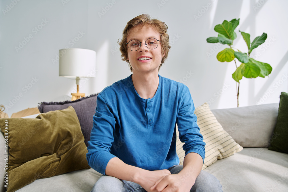 Webcam portrait male student teenager with glasses, sitting at home