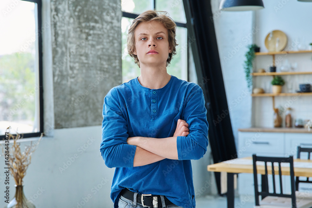 Portrait of confident serious teenage boy with crossed arms