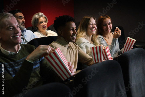 Obraz na płótnie Group of happy multi ethnic friends enjoying film screening and eating popcorn at the movie theater w salonie