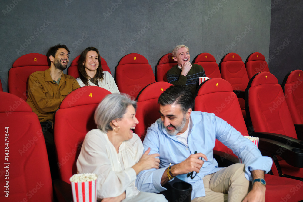 People enjoying a funny movie together at the cinema, eating popcorn and having fun