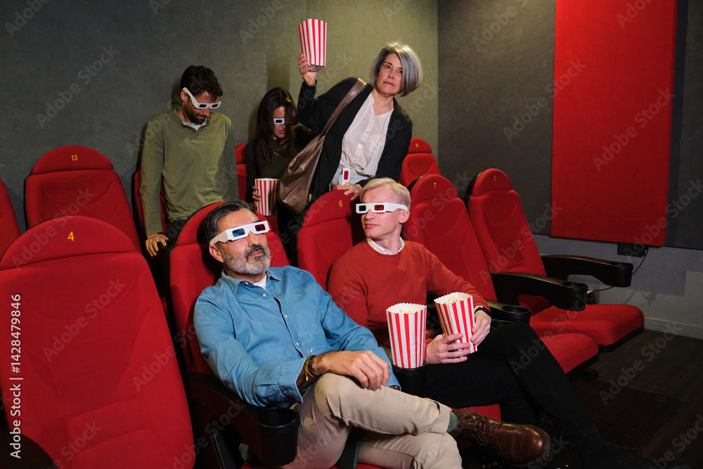 A mature woman enters the cinema late, accidentally disrupting the other viewers as she looks for her seat