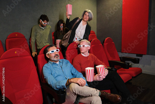 Obraz na płótnie A mature woman enters the cinema late, accidentally disrupting the other viewers as she looks for her seat w salonie