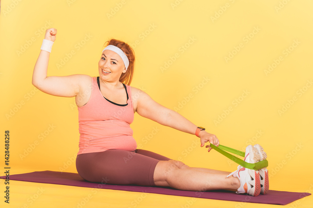 A woman is doing a yoga pose with a green resistance band