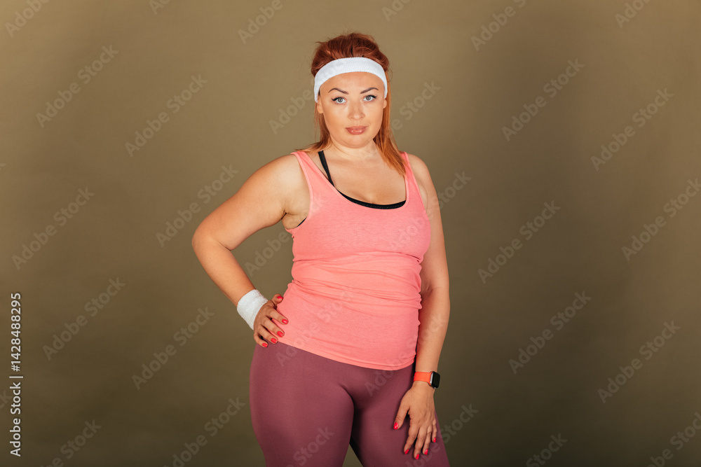 A woman in pink tank top and purple pants poses for a photo