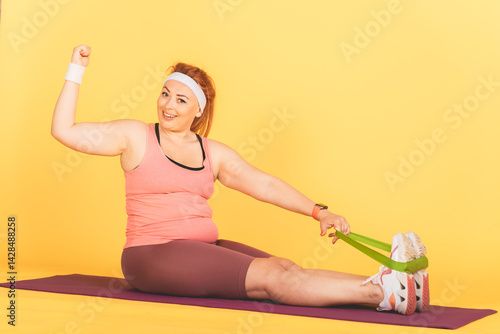 Obraz na płótnie A woman is doing a yoga pose with a green resistance band w salonie