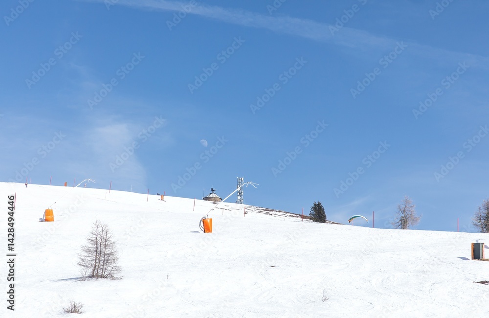 Snow-covered mountain slope with ski equipment under clear blue sky Snow-covered mountain slope with ski equipment under clear blue sky