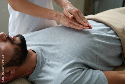 close-up view of bearded man receiving reiki healing session above stomach and chest