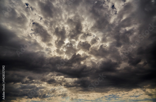 Fototapeta Naklejka Na Ścianę i Meble -  A large shelf cloud on a dark sky blocking sunlight, close-up, cloud background, gloomy tones of the evening sky before rain, texture of dark clouds in the sky, ominous clouds in the sky