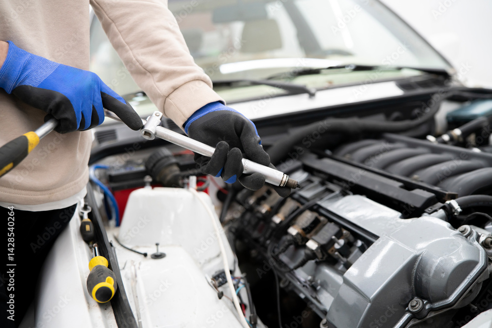 Car Mechanic Utilizes Spark Plug Wrench for Efficient Engine Maintenance in a Professional Workshop Setting Car Mechanic Utilizes Spark Plug Wrench for Efficient Engine Maintenance in a Professional Workshop Setting