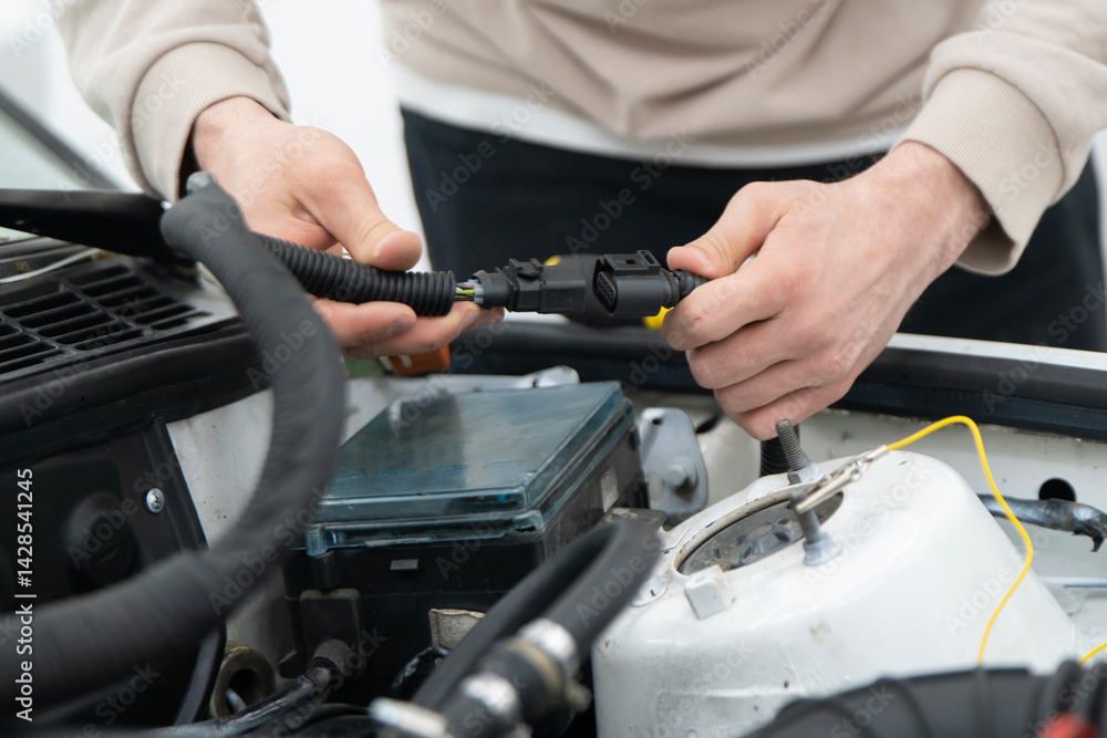 Mechanic Connects Car Wire Harness Connectors While Servicing a Vehicle Engine in a Workshop Setting