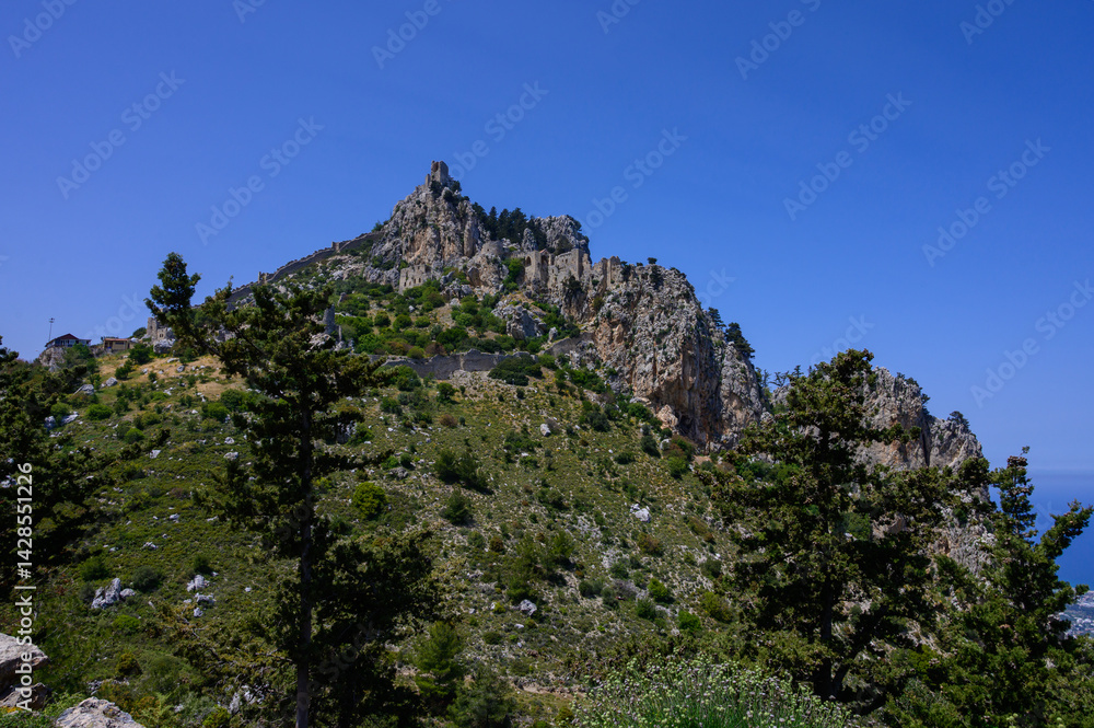 Ancient walls and towers of St. Hilarion Castle, an iconic historical site perched on a mountain in Cyprus.