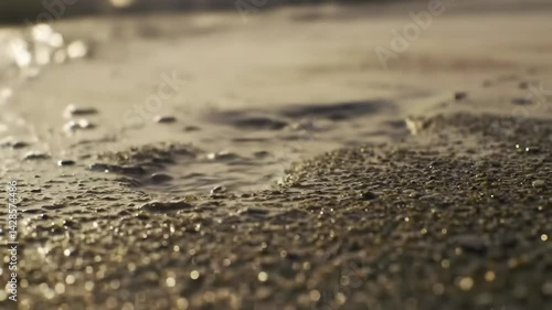 Wallpaper Mural Close-up of a Water Droplet Pooling in Sandy Shoreline with Gentle Waves Lapping, Capturing the Beauty of Natural Textures and Light Reflections at the Beach Torontodigital.ca