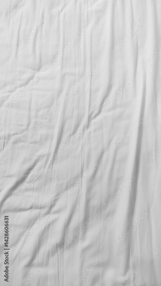 Obraz premium A serene close-up of soft white bedding with gentle creases and folds, creating a calming, textured look. Ideal for lifestyle, comfort, and interior design themes