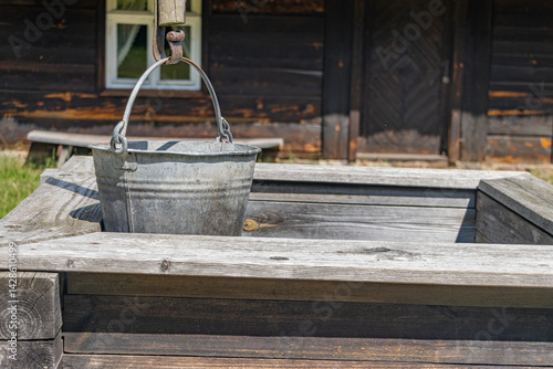 Obraz na płótnie Old wooden well with a bucket on a pulley w salonie