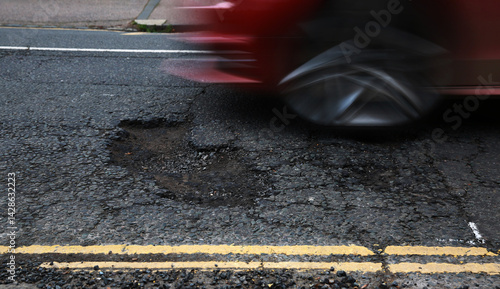 Tableau sur toile A car travelling towards a pothole