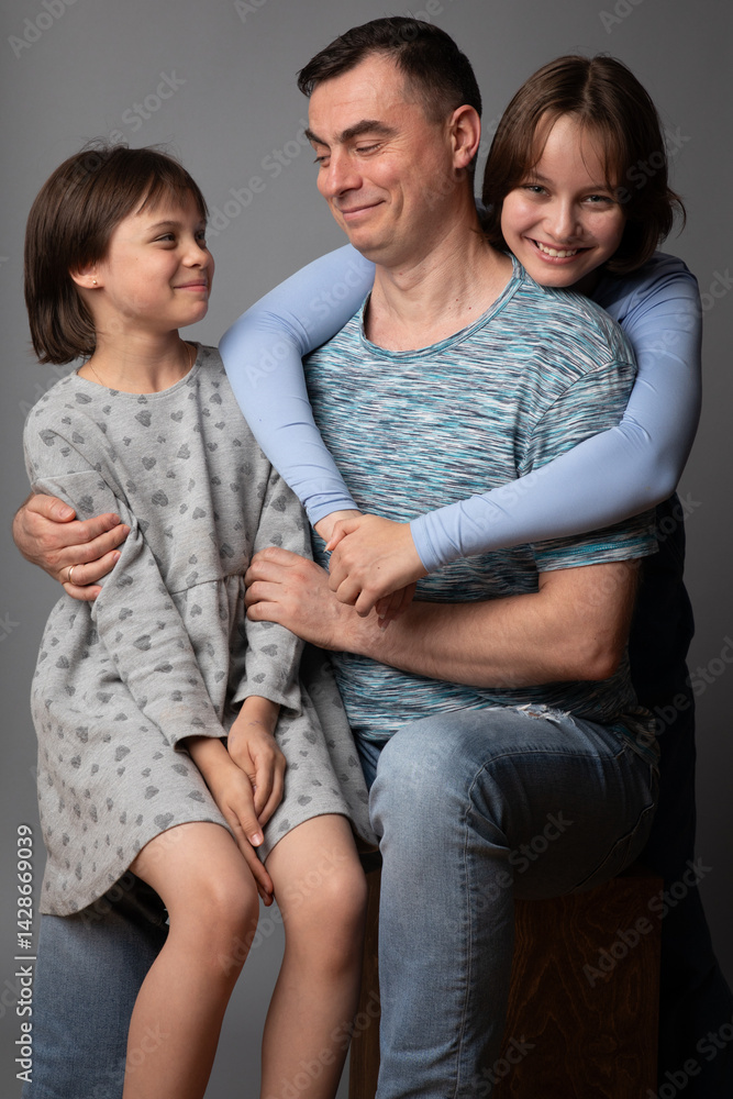 Studio portrait of family: father and daughters