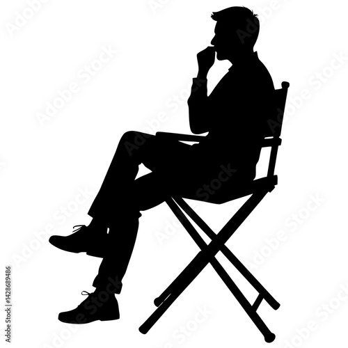 Silhouette of man sitting in director chair