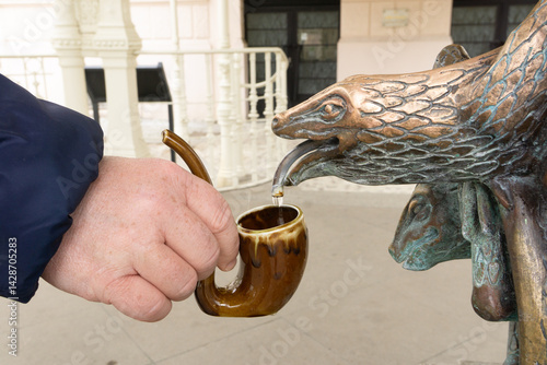 Cuadro en lienzo A hand holding a mug, pouring water from a healing spring in Karlovy Vary