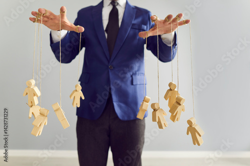 Tableau sur toile Boss and company leader pulls strings with little human shaped puppets as symbol of manipulating, influencing, exploiting, and violating rights of employees