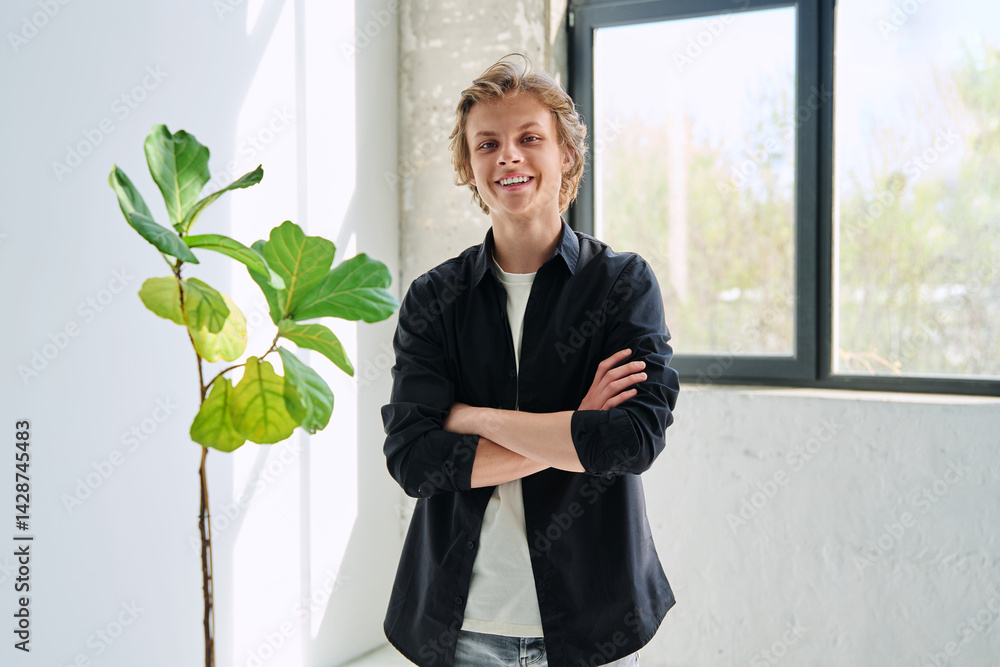 Portrait of confident happy teenage boy with crossed arms