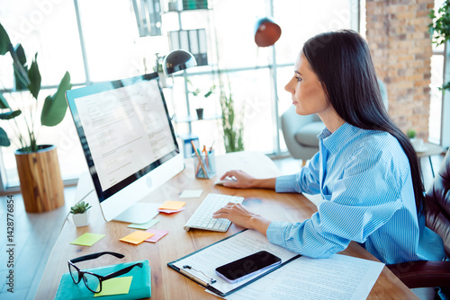 Valokuva Young professional woman working in an office environment, viewing her screen at