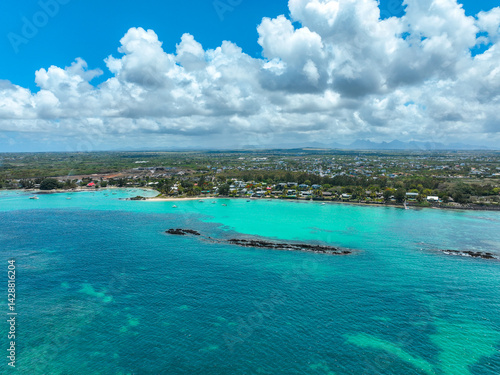 Aerial panorama of Grand Baie coastline with homes, beach, and turquoise waters