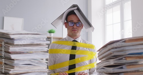 Exhausted sad deadline tired businessman, adhesive tape wrapped at workplace with loaded paper work, stressed frustrated unhappy unproductive employee asking for help, sos showing