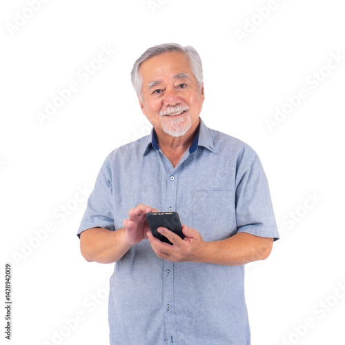 Smiling Asian senior man using smartphone, standing and touching screen casually in casual shirt, showing technology adoption, communication, digital lifestyle, isolated on a transparent background