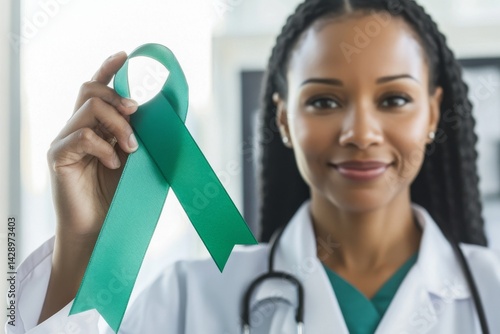 Obraz na płótnie A beautiful black doctor, a woman, is pointing with her hand and finger while smiling and holding a green ribbon to support awareness of mental health w salonie