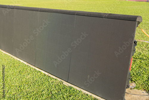 Wallpaper Mural A detailed view of a large outdoor digital display panel located on a grassy field, illustrating modern technology used in sports and event broadcasting in outdoor settings. Torontodigital.ca