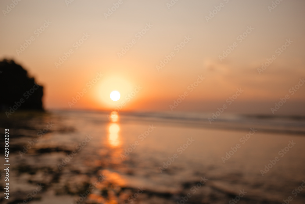 Obraz premium View of the orange sunset over the ocean is out of focus. Beautiful blurred background of nature and evening sky