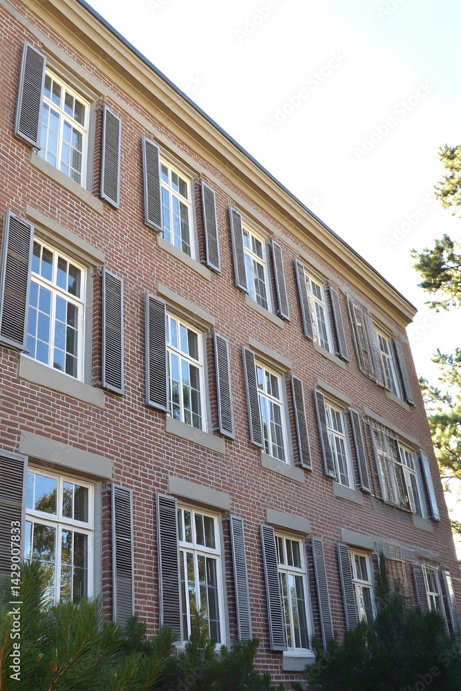 Classic Brick Building Exterior with Gray Shutters and Windows Classic Brick Building Exterior with Gray Shutters and Windows