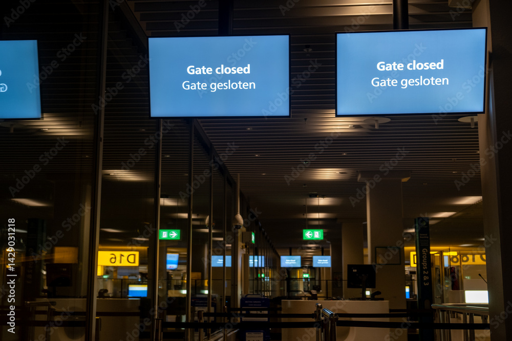 Gate closed sign showing on multiple screens in deserted airport terminal