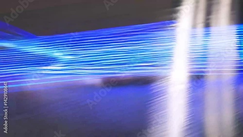 Amazing sight of speedy bright blue light beams bouncing off a metal surface while the camera follows the action.