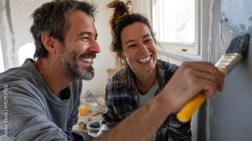 Happy couple painting wall together during home renovation project indoors