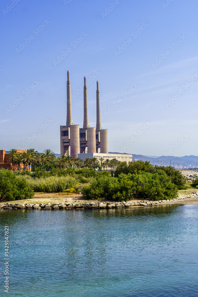 Obraz premium Panoramic View of Sant Adriá Thermal Power Station with its Three Imposing Chimneys under the Blue Sky”