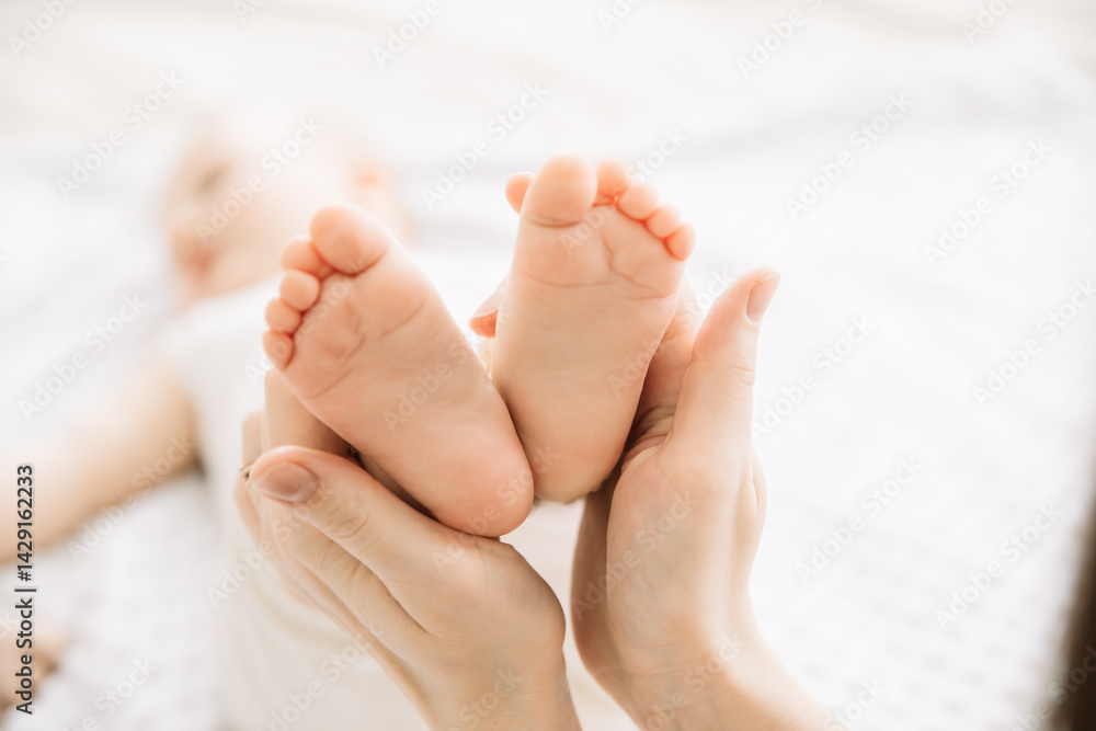 mother holds baby's heels. concept of childhood and motherhood mother holds baby's heels. concept of childhood and motherhood